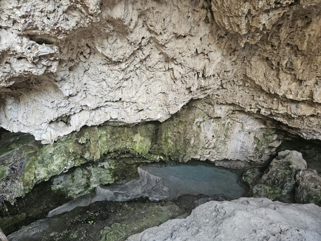 A cave with a pool of water inside of it